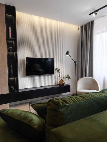 a living room with a couch and a flat screen tv at ZEST Verde in Kragujevac