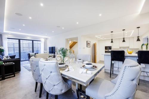 格拉茨克洛斯的住宿－Modern Home in Gerrards Cross With Free Parking By AV Stays，用餐室以及带桌椅的厨房。