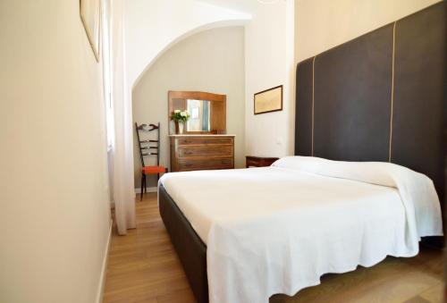 a bedroom with a large white bed with a black headboard at San Giacomo Apartment in Venice