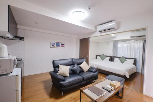 a living room with a couch and a bed at Coral Gate in Kume コーラルゲートイン久米 in Naha