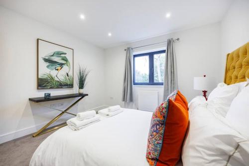 - une chambre blanche avec un grand lit et une fenêtre dans l'établissement Modern Home in Gerrards Cross With Free Parking By AV Stays, à Gerrards Cross