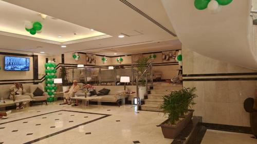 a lobby with people sitting on couches in a building at Emaar Taiba Hotel in Al Madinah