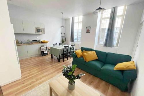 un salon avec un canapé vert et une table dans l'établissement Superbe T3 en centre-ville et facile d'accès, à Orléans