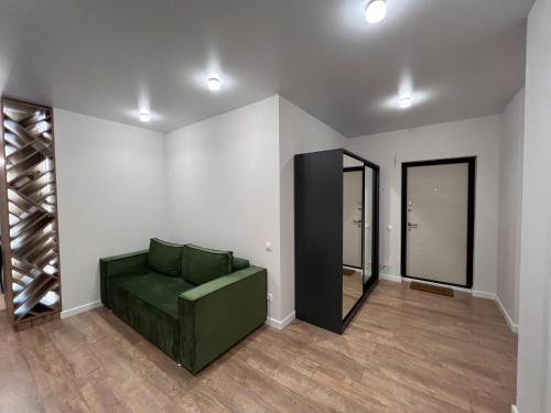 uma sala de estar com um sofá verde e portas de vidro em Renthouse Apartments Level Up em Chisinau