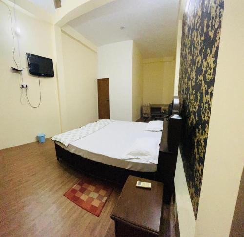 ein kleines Schlafzimmer mit einem Bett und einem Tisch in der Unterkunft RN Residency in Varanasi