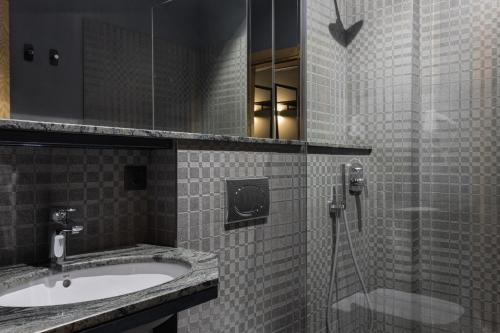 La salle de bains est pourvue d'un lavabo et d'une douche. dans l'établissement Plai Hotel, à Chişinău