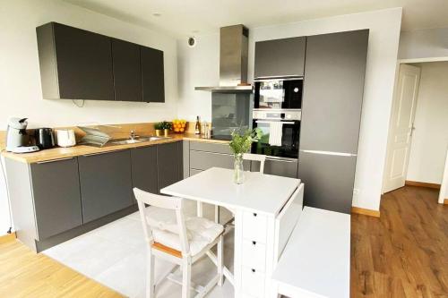 une cuisine avec une table et une chaise blanches dans l'établissement Maison duplex en plein centre d'Orléans, à Orléans