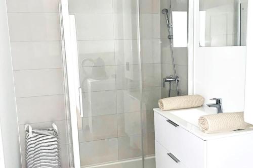 une salle de bain blanche avec une douche et un lavabo dans l'établissement Maison duplex en plein centre d'Orléans, à Orléans