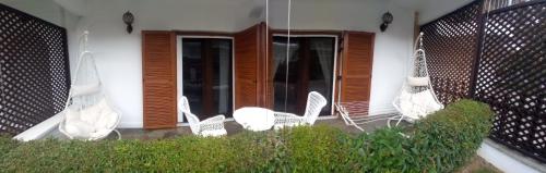 a group of white chairs sitting outside of a house at Amaryllis House in Platamonas