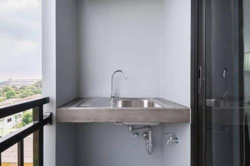 a stainless steel sink in a bathroom with a window at Aqua Residences อควา เรสซิเดนซ์ ห้องพักใหม่ให้เช่า ติดรถไฟฟ้าสถานีวุฒากาศ in Thonhuri