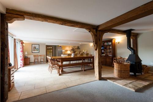 a large living room with a table and a fireplace at Marshlands House, Sleeps 16 - Country barn with hot tub in Woodbridge