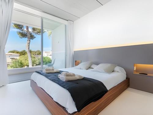 a bedroom with a large bed with a large window at Villa Cuc in Playa de Muro
