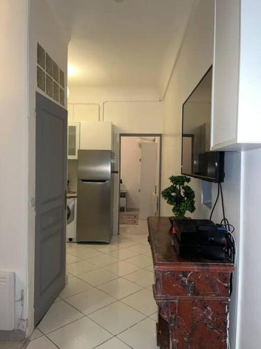 a kitchen with a refrigerator and a table with a plant at Le Bourget super appartement au centre ville in Le Bourget