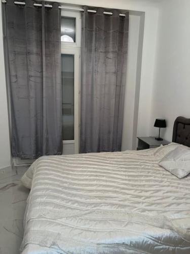 - une chambre avec un grand lit et une fenêtre dans l'établissement Le Bourget super appartement au centre ville, au Bourget