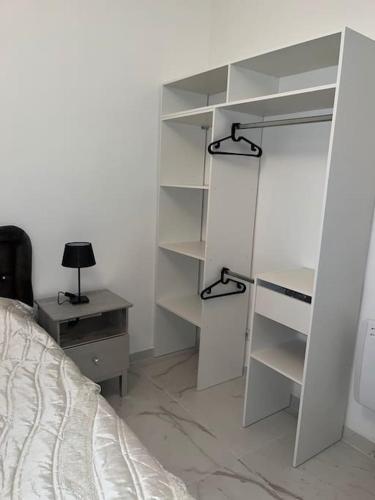 a bedroom with a bed and a desk and shelves at Le Bourget super appartement au centre ville in Le Bourget