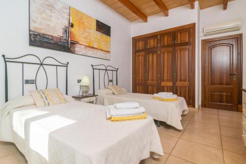 two beds in a room with white walls at Can Berguins in Búger