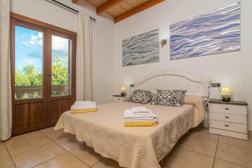 a bedroom with a bed with towels on it at Can Berguins in Búger