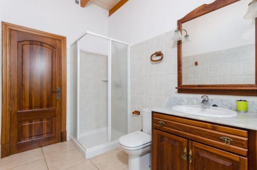 a bathroom with a shower and a toilet and a sink at Can Berguins in Búger