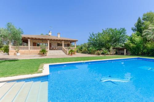 a villa with a swimming pool in front of a house at Can Berguins in Búger