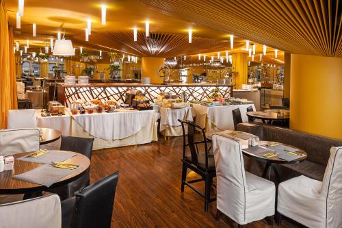 een eetkamer met tafels en witte stoelen en een tafeltennistafel bij Perla Hotel in Praag