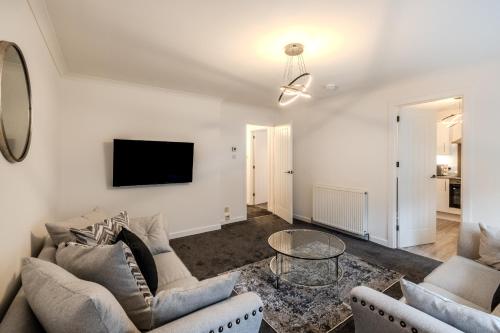 a living room with two couches and a tv at Central City Hideaway - Luxury 2 Bed city centre Apartment in Aberdeen
