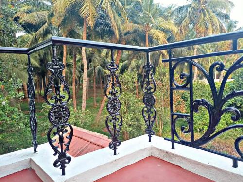 een balkon met een leuning met palmbomen op de achtergrond bij Reves by Le Apex in Kottakupam