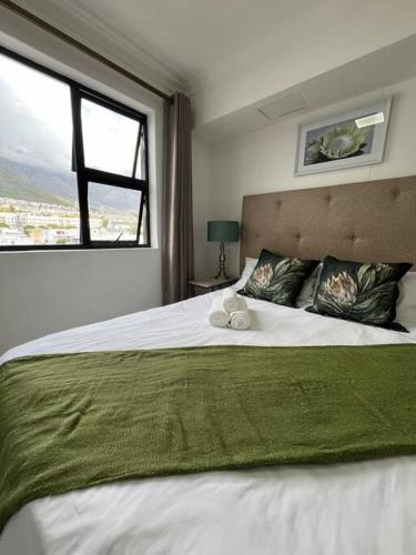a bedroom with a large white bed with a window at Modern Apartment in Chapel Towers in Cape Town