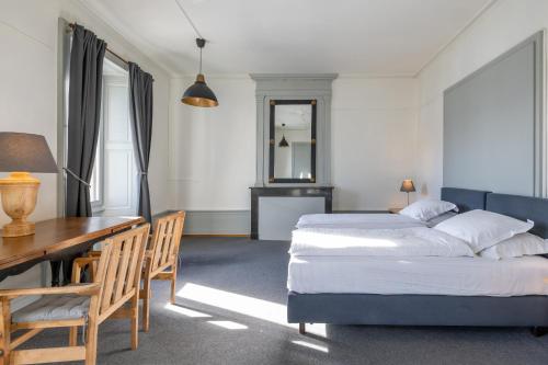 a bedroom with a bed and a desk and a table at Vevey House in Vevey