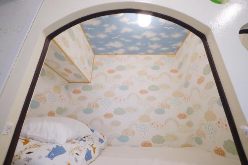 a bedroom with a bed and a wall with clouds at Coral Gate in Kume コーラルゲートイン久米 in Naha
