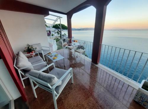 a balcony with chairs and a view of the ocean at Villa Paradise (Amalfi Coast - Luxury Home - Beach) in Vietri sul Mare