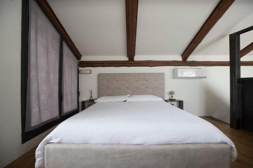 a large white bed in a room with windows at Casa Silvana in Alba