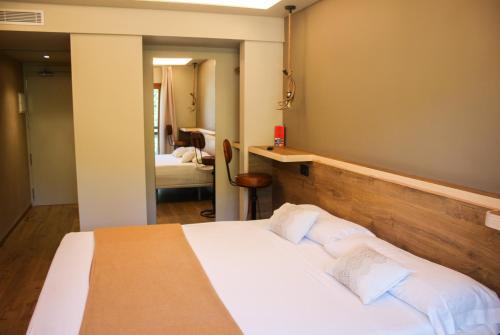 a bedroom with a large bed and a mirror at Hotel Vall d´Aneu in Esterri d'Àneu