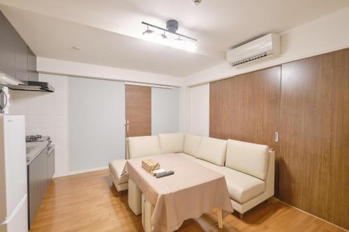 a living room with a white couch and a table at Coral Gate in Kume コーラルゲートイン久米 in Naha