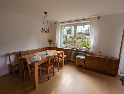 comedor con mesa, sillas y ventana en Ferienwohnung Am Seebach, 80 Qm en Titisee-Neustadt