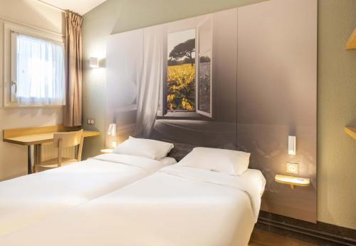 ナントにあるB&B HOTEL Nantes Parc Expos La Beaujoireの窓付きの部屋のベッド3台