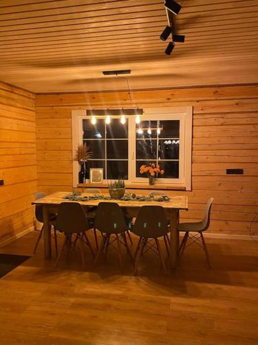 a dining room with a table with chairs and a window at Sodyba vienkiemyje "Šeimos slėnis" in Kupiškis
