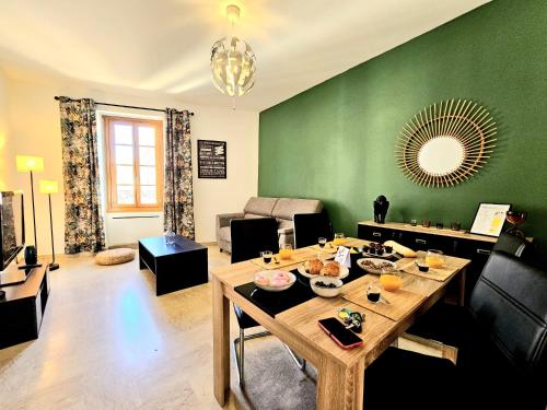 - un salon avec une table et un mur vert dans l'établissement Aréna - 2 chambres - vue sur les arènes, à Nîmes