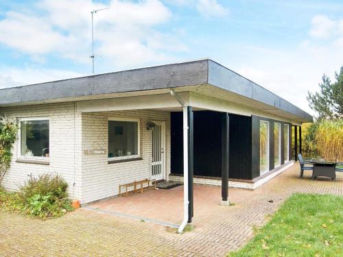 uma pequena casa branca com um telhado preto em 8 person holiday home in Asn s em Asnæs