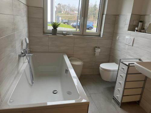a bathroom with a tub and a toilet and a sink at Ferienwohnung 20b am Goitzsche See in Pouch