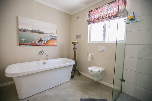 a bathroom with a bath tub and a toilet at On Salisbury in Cape Town