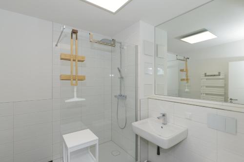 a white bathroom with a sink and a shower at Apartmenthaus Strandstraße 34 in Kühlungsborn