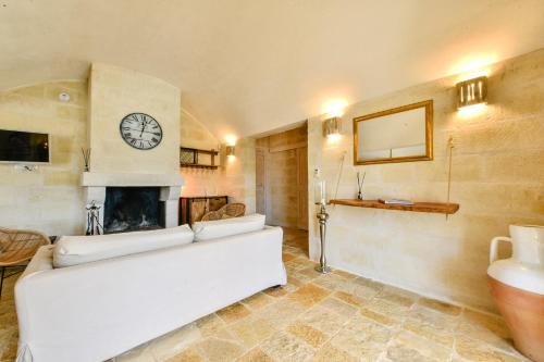 a living room with a white couch and a fireplace at Villa Merlata in Ostuni