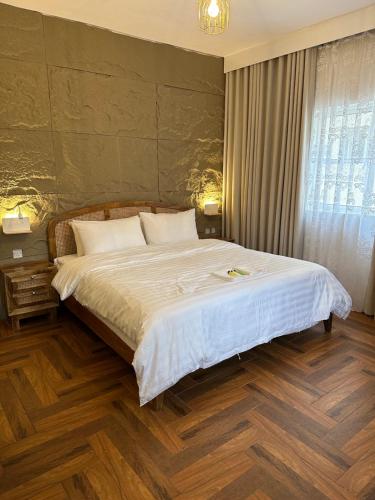 um quarto com uma cama grande e lençóis brancos em Dar Sayang em Taif