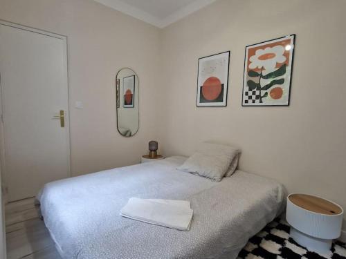 une chambre blanche avec un lit et un miroir dans l'établissement Appartement Cosy centre-ville, à Angers