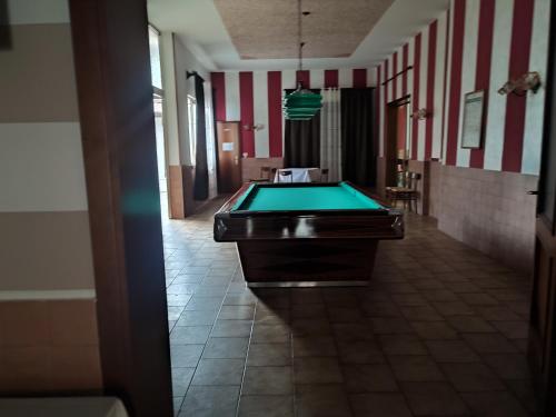 un tavolo da biliardo in una stanza a strisce rosse e bianche di LOCANDA TRIESTE a Bonavigo