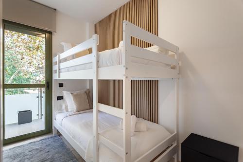 a white bunk bed in a room with a window at Cozy Apartment Les Corts in Barcelona