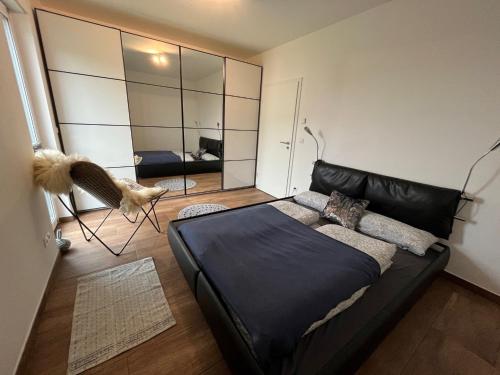 a bedroom with a black leather couch and a mirror at Ferienwohnung Spanier in Pouch