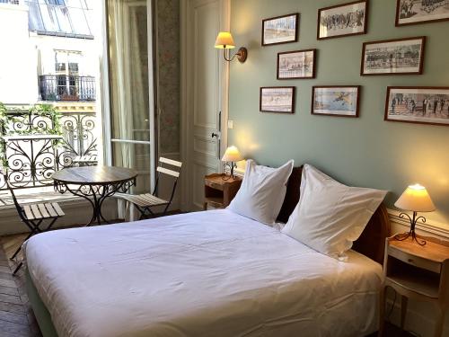 Un dormitorio con una gran cama blanca y una mesa en Bed and Breakfast Paris Arc de Triomphe, en París