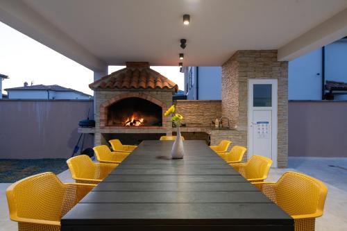 une salle à manger avec une table et une cheminée dans l'établissement Villa Hugo, à Vodnjan