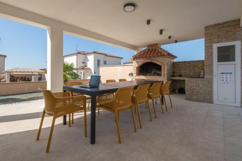 a patio with a table and chairs and a fireplace at Villa Hugo in Vodnjan